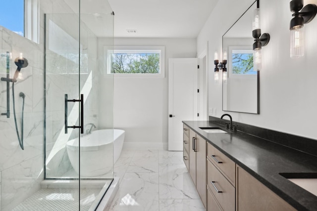 bathroom with marble finish floor, a healthy amount of sunlight, a sink, and double vanity