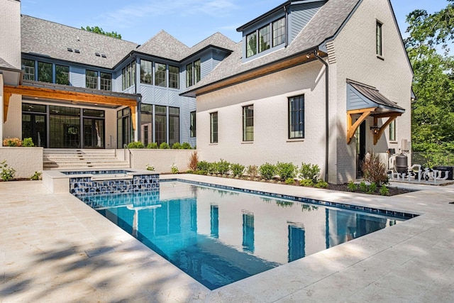 2811 Tyne Blvd, Nashville, TN 37215 - back of house with brick siding, a pool with connected hot tub, a sunroom, and a patio