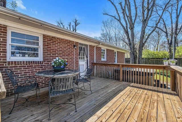 wooden terrace featuring outdoor dining space and fence