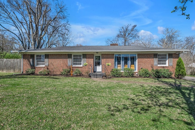 ranch-style home featuring brick siding, a front lawn, fence, and a chimney
