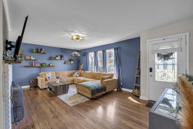 living room featuring baseboards, wood finished floors, and a fireplace