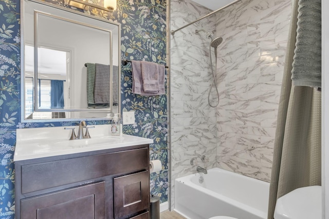 full bath with wallpapered walls, vanity, toilet, and shower / bath combo