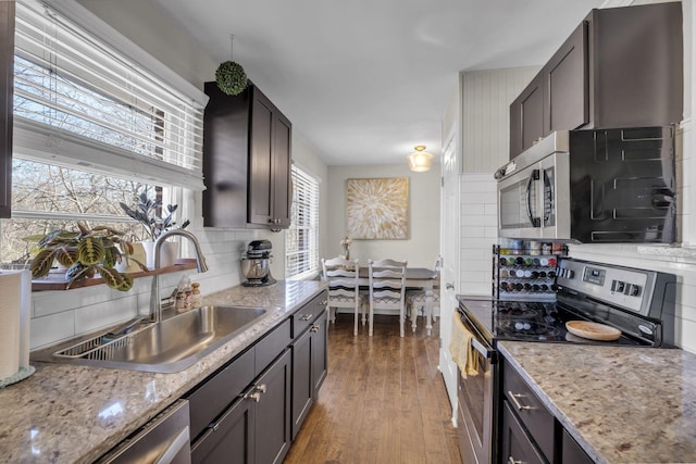 kitchen featuring tasteful backsplash, appliances with stainless steel finishes, dark wood-style floors, and a sink