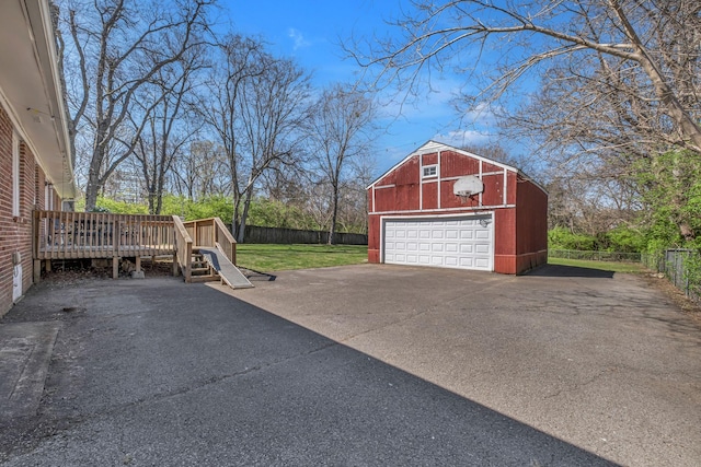 garage featuring a detached garage and fence