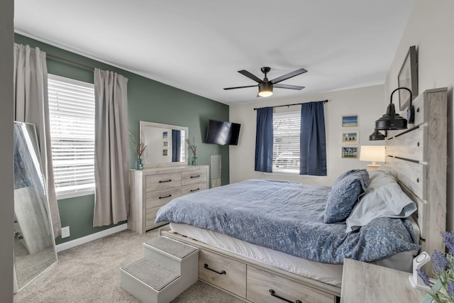 bedroom with ceiling fan, baseboards, and light colored carpet