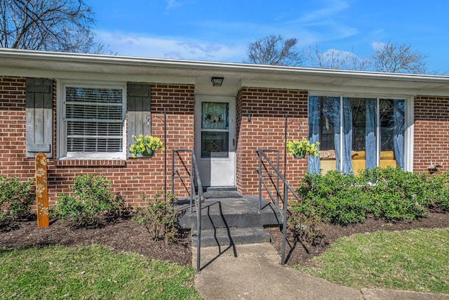 doorway to property with brick siding