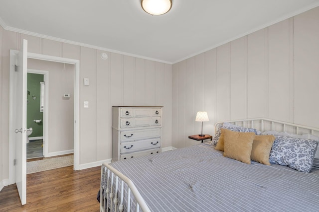 bedroom featuring baseboards, crown molding, and wood finished floors