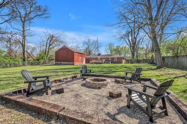 view of yard featuring fence, an outdoor fire pit, an outdoor structure, and a barn
