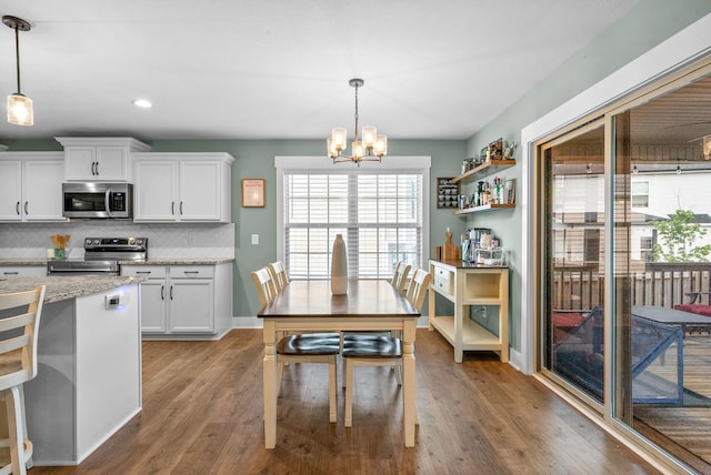 237 Wade Hampton Ln, Clarksville, TN 37040 - kitchen featuring decorative backsplash, appliances with stainless steel finishes, wood finished floors, white cabinets, and an inviting chandelier