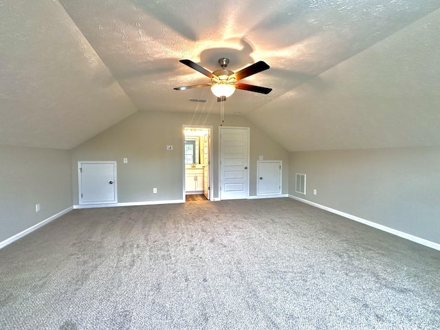 bonus room with lofted ceiling, a ceiling fan, a textured ceiling, and carpet floors