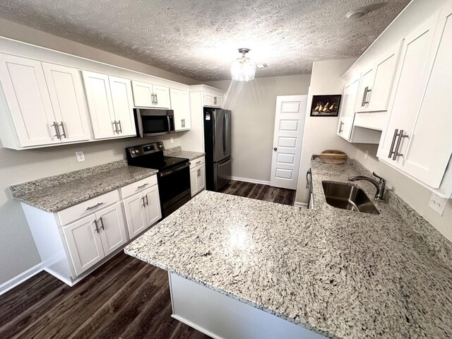 kitchen with stainless steel appliances, dark wood-style floors, a sink, and white cabinetry