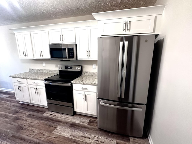 kitchen featuring white cabinetry, appliances with stainless steel finishes, baseboards, and dark wood-style flooring