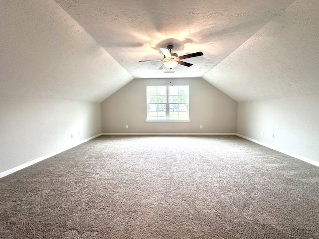 bonus room with vaulted ceiling, carpet floors, and a textured ceiling