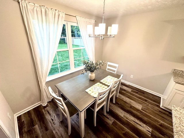 dining space featuring dark wood finished floors, baseboards, and a notable chandelier