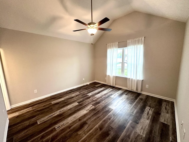 empty room featuring lofted ceiling, baseboards, ceiling fan, and dark wood finished floors