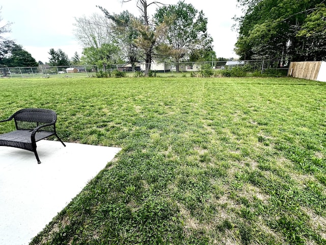 view of yard featuring fence and a patio