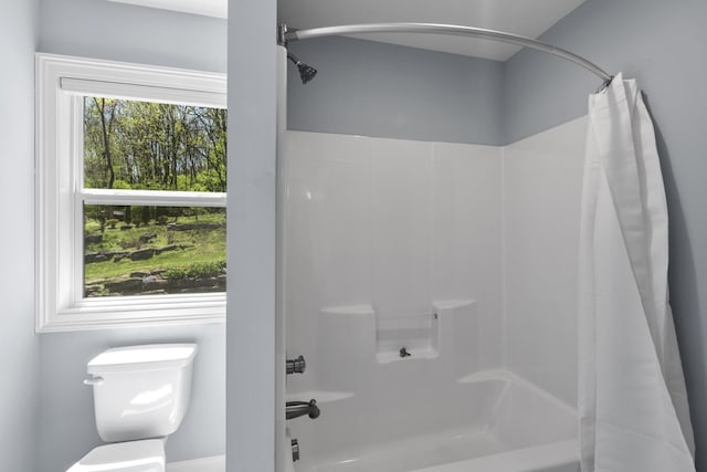 bathroom featuring shower / bath combination with curtain and toilet