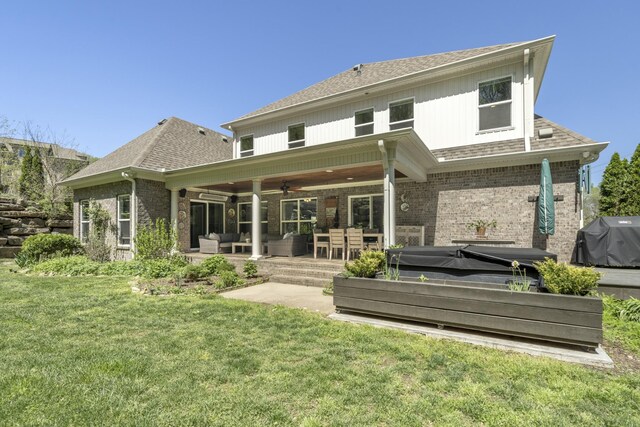 back of property with a ceiling fan, a yard, outdoor lounge area, and brick siding
