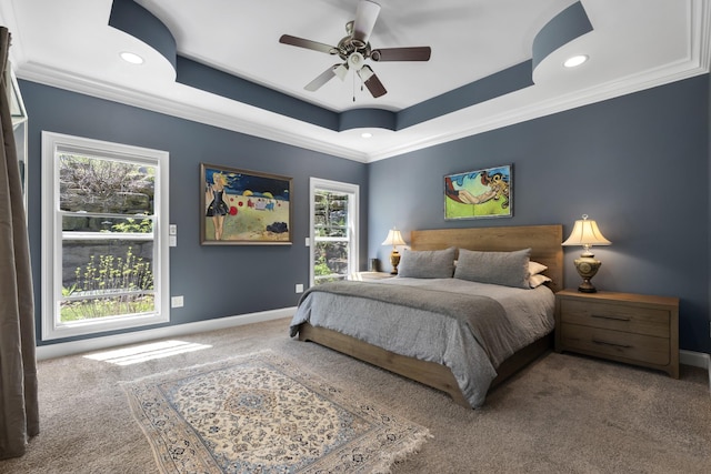 carpeted bedroom with a raised ceiling, crown molding, recessed lighting, and baseboards