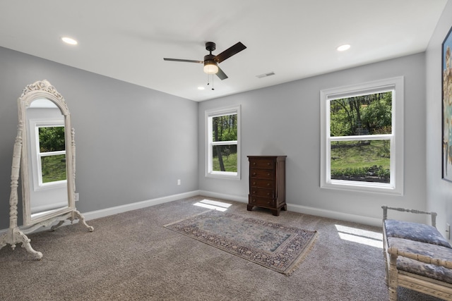 unfurnished room with visible vents, a wealth of natural light, and carpet