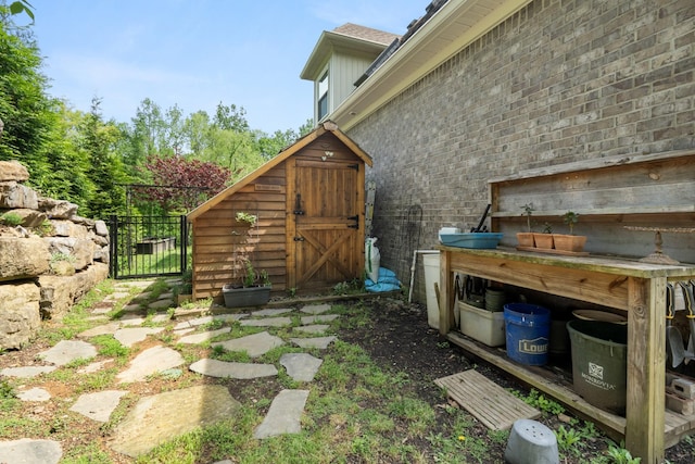view of yard with an outbuilding, a storage shed, and a gate