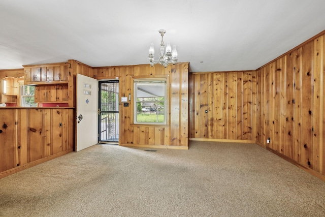 909 Hillsboro Rd, Franklin, TN 37064 - unfurnished living room with wood walls, a notable chandelier, and carpet