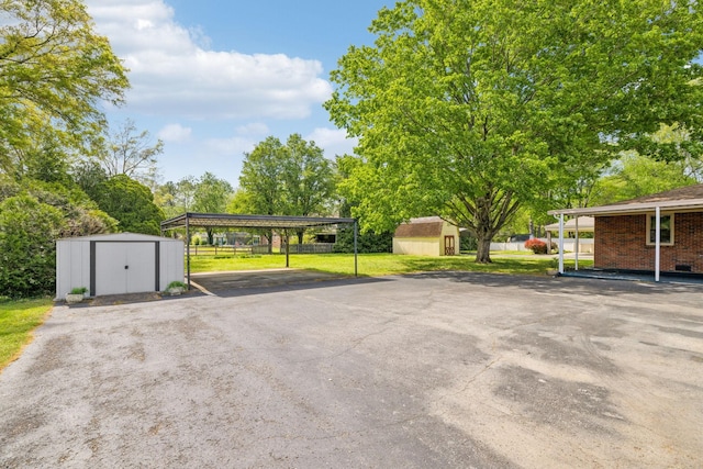 909 Hillsboro Rd, Franklin, TN 37064 - view of parking / parking lot with fence, a carport, aphalt driveway, and a storage shed