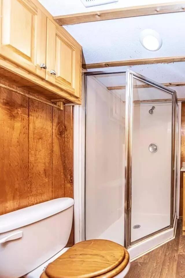 5755 Railroad St, Williston, TN 38076 - full bathroom featuring toilet, a stall shower, and wood finished floors