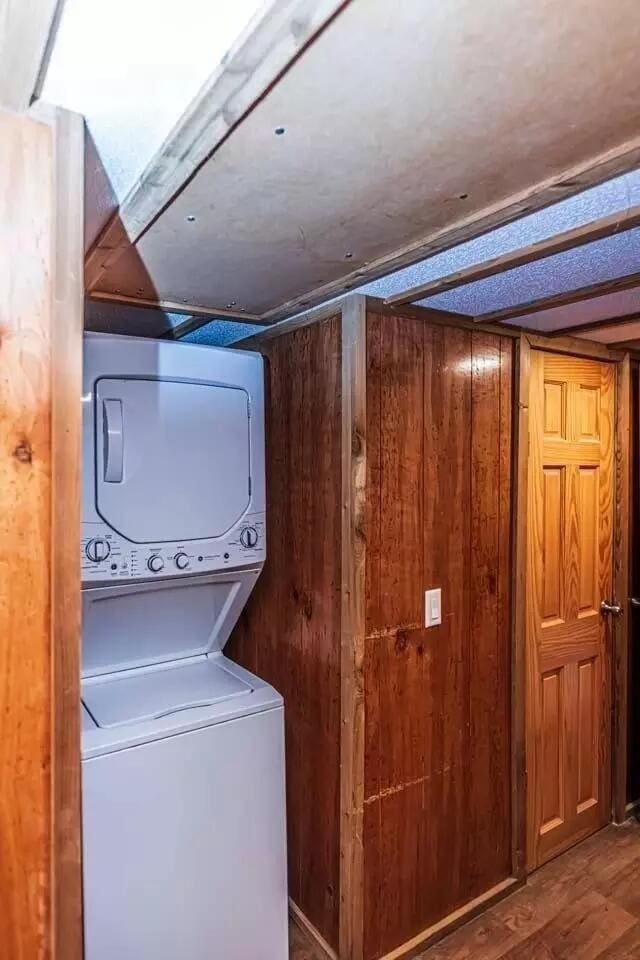 5755 Railroad St, Williston, TN 38076 - laundry area featuring stacked washer / dryer and wood walls