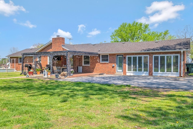 1803 W Lori Lee Dr, Gallatin, TN 37066 - back of house with a chimney, brick siding, a yard, and a patio