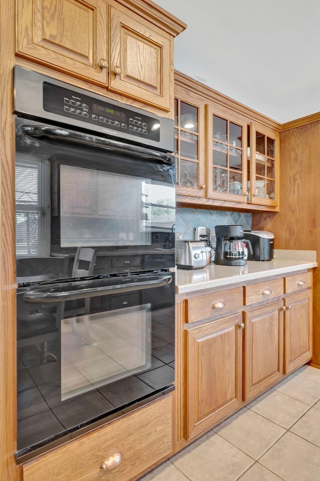 1803 W Lori Lee Dr, Gallatin, TN 37066 - kitchen with dobule oven black, glass insert cabinets, decorative backsplash, light countertops, and light tile patterned floors