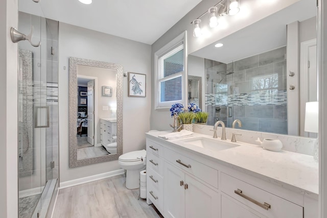 1803 W Lori Lee Dr, Gallatin, TN 37066 - bathroom with a stall shower, toilet, baseboards, wood finished floors, and vanity