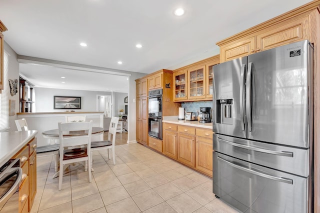 1803 W Lori Lee Dr, Gallatin, TN 37066 - kitchen with recessed lighting, light countertops, light tile patterned floors, dobule oven black, and stainless steel refrigerator with ice dispenser