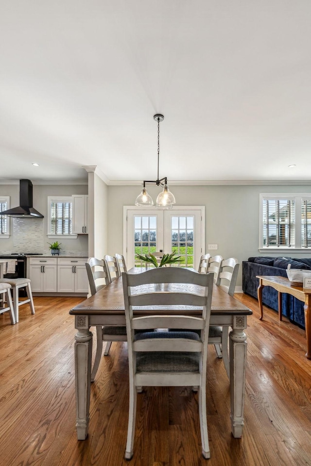 dining area featuring ornamental molding and light wood-type flooring