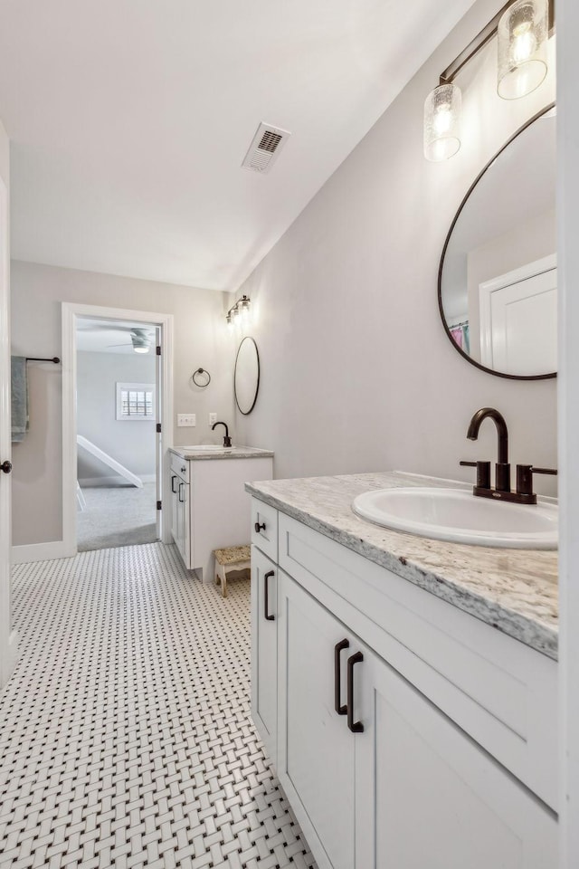 bathroom with two vanities and baseboards