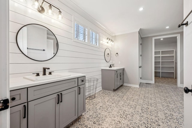 full bath with ornamental molding, baseboards, two vanities, recessed lighting, and wooden walls