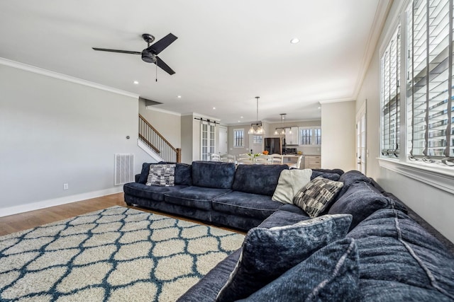 living area featuring crown molding, wood finished floors, a ceiling fan, recessed lighting, and baseboards