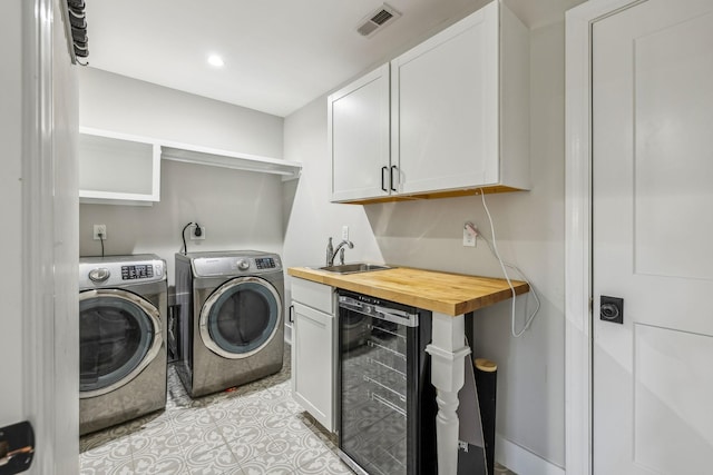 laundry room with wine cooler, a sink, washing machine and clothes dryer, and light tile patterned floors