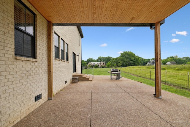 view of patio with fence and a grill