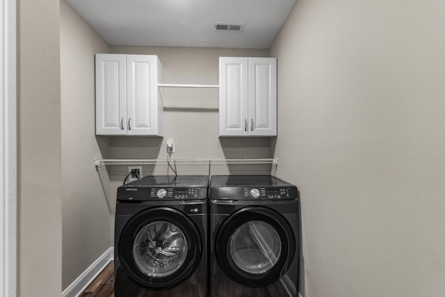 laundry room with baseboards, visible vents, wood finished floors, independent washer and dryer, and cabinet space