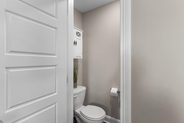 bathroom featuring toilet and baseboards