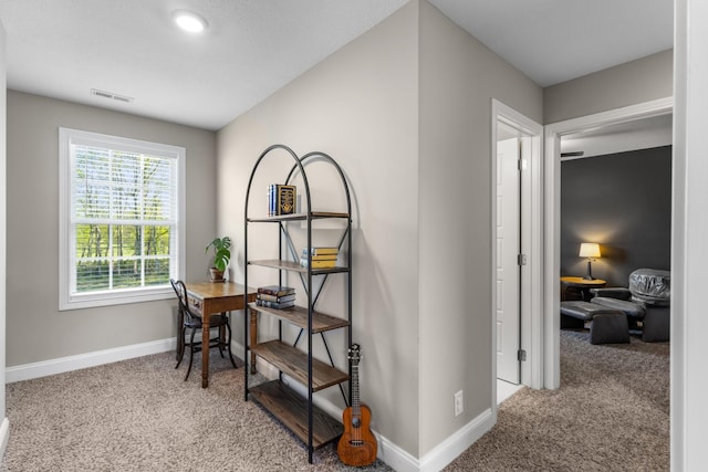 corridor with carpet, visible vents, and baseboards