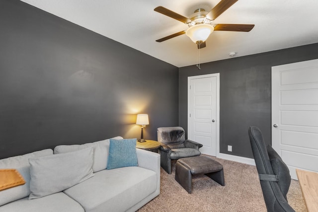 carpeted office space featuring ceiling fan and baseboards