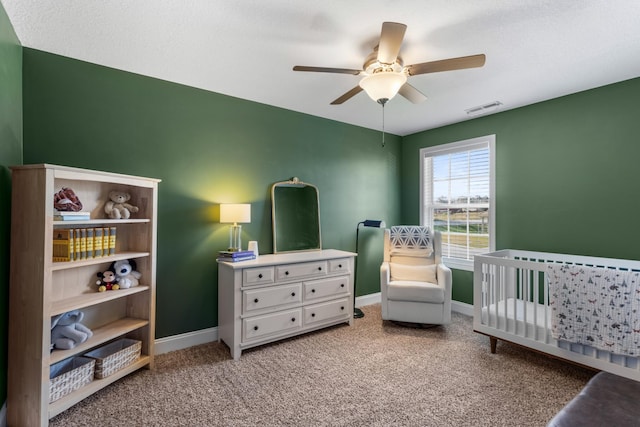 bedroom featuring a nursery area, baseboards, carpet flooring, and visible vents