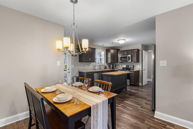 dining space featuring a notable chandelier, baseboards, and dark wood-style flooring
