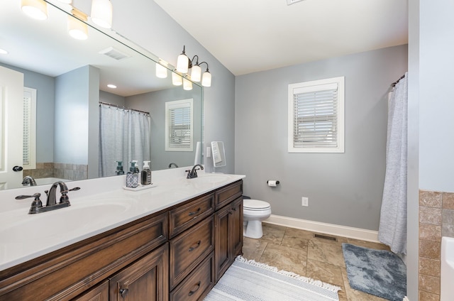 full bathroom with double vanity, visible vents, toilet, and a sink