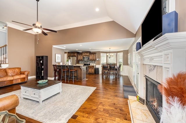 living area with recessed lighting, dark wood-style floors, crown molding, a fireplace, and ceiling fan with notable chandelier