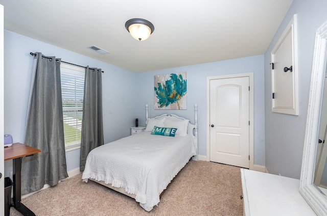 bedroom featuring visible vents, baseboards, and light carpet