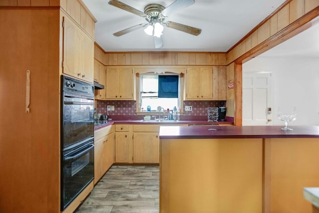 kitchen featuring backsplash, dark countertops, dobule oven black, and a sink