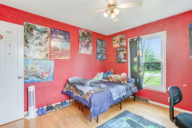 bedroom with visible vents, baseboards, a ceiling fan, and wood finished floors